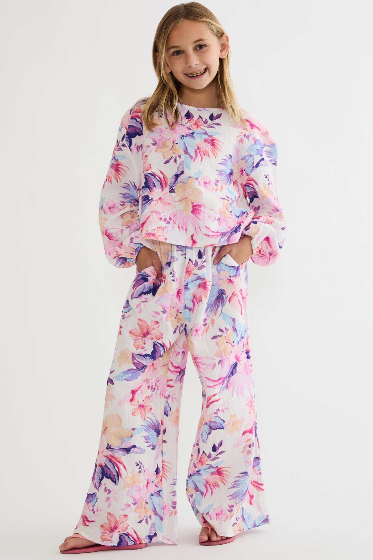Young girl wearing a colorful floral outfit on a white background
