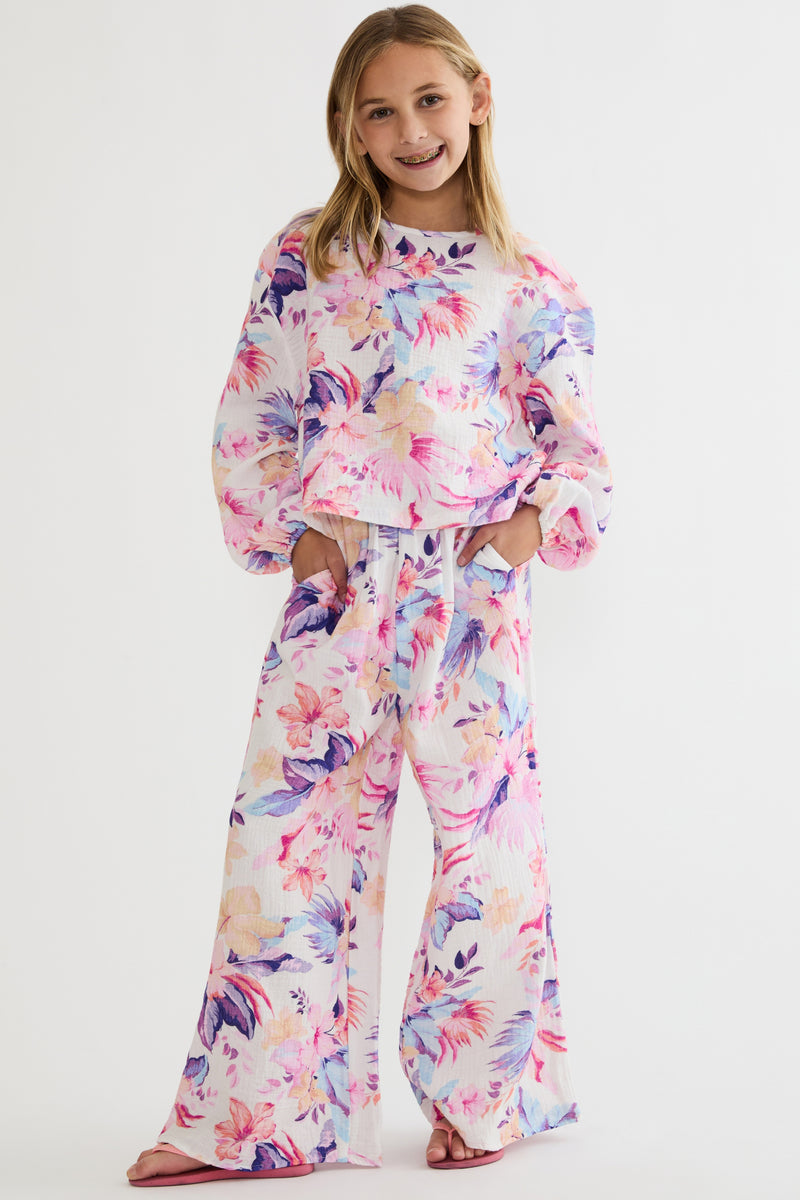 Young girl wearing a colorful floral outfit on a white background