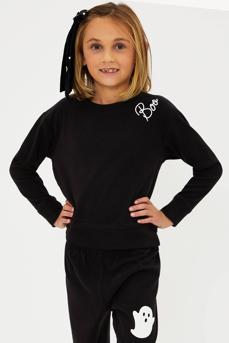 Child wearing a black outfit with ghost designs on a white background