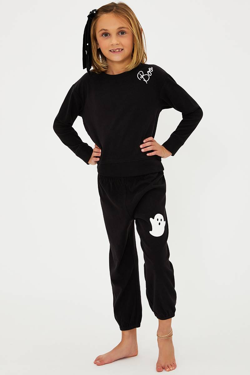 Child wearing a black outfit with a ghost design on a white background