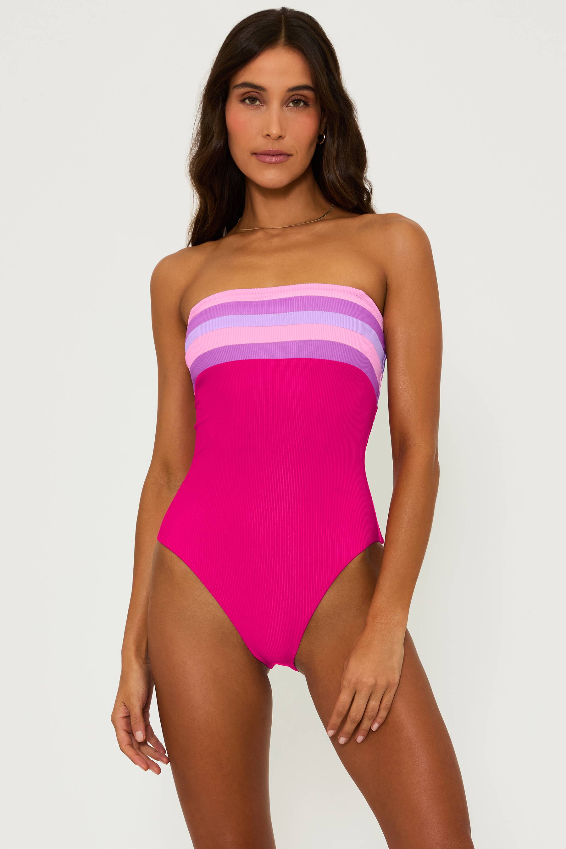 magenta ribbed one piece swim suit with pink and purple stripes on the bust