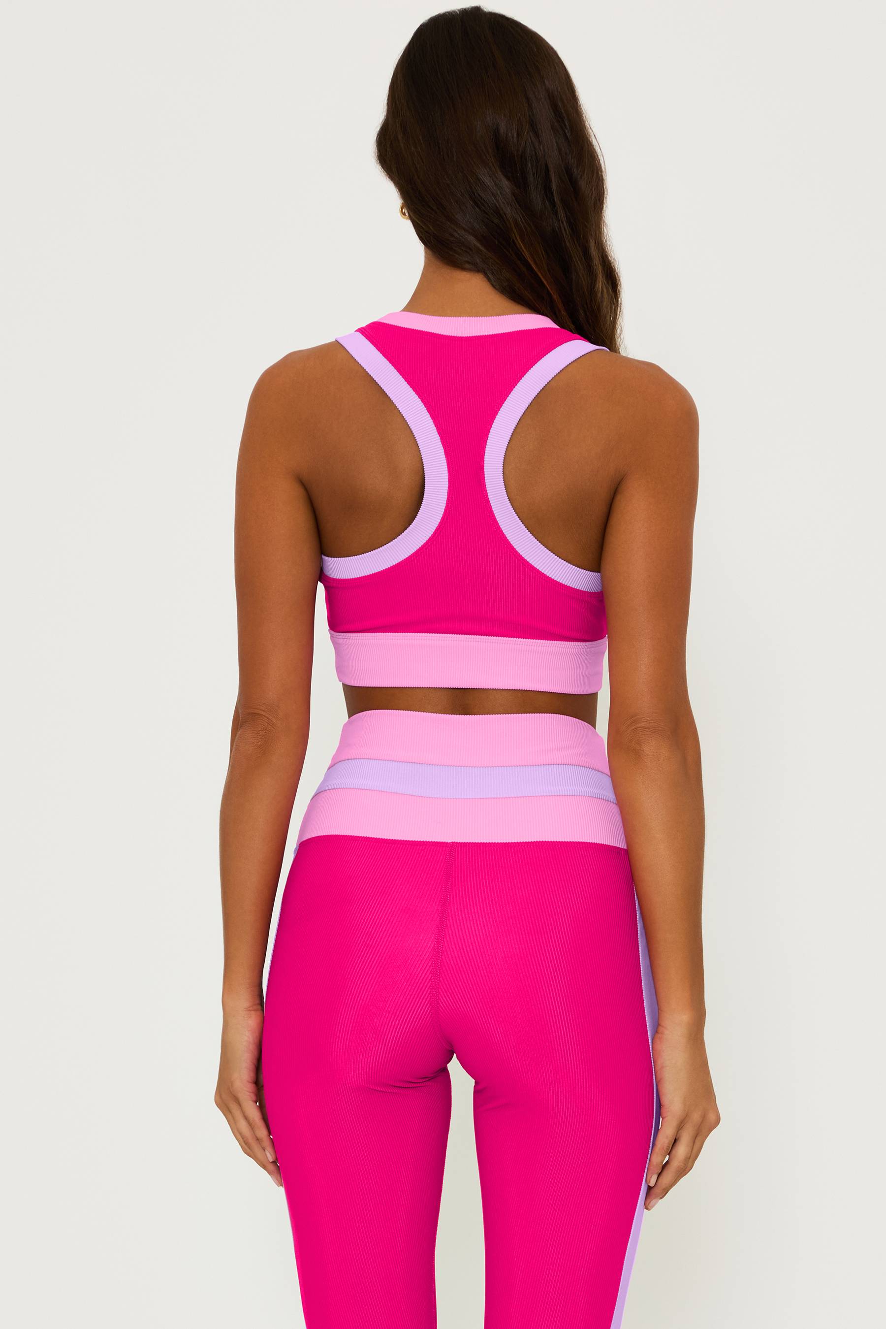 ribbed magenta high neck sports bra with pink and purple contrast trim